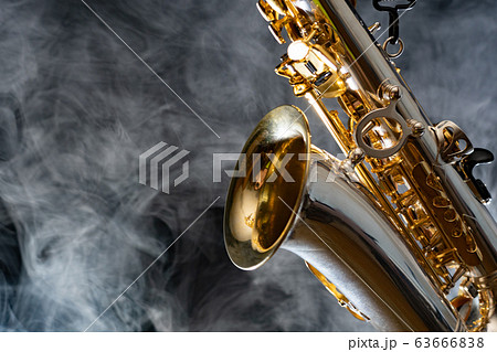 Golden shiny alto saxophone on black background with smoke. copy space 63666838