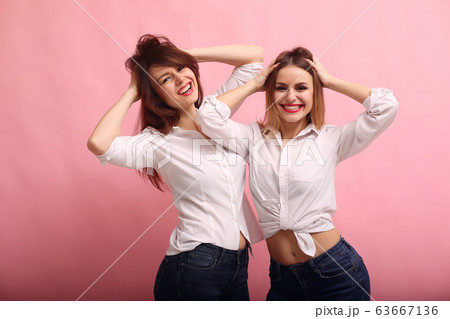Fashion girls posing on a pink background 63667136
