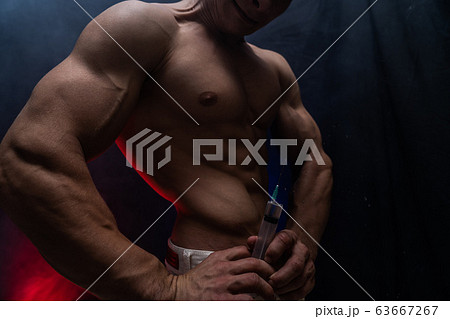 Bodybuilder holding big syringe with injection. concept of steroid in the sport and addiction Bodybuilder holding big syringe with injection. concept of steroid in the sport and addiction 63667267