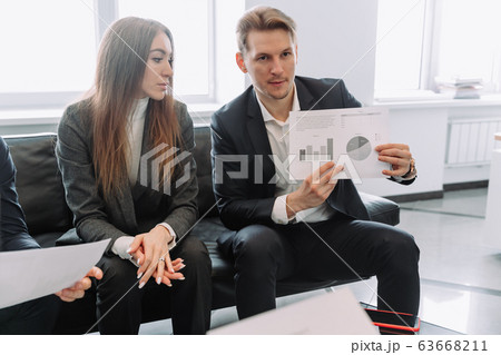 businessman with a partner a girl talks in the office business partners view the sales schedule 63668211