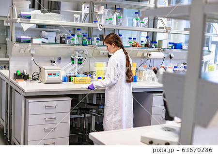 Girl scientist studying notes near lab equipment Girl scientist studying notes near lab equipment 63670286