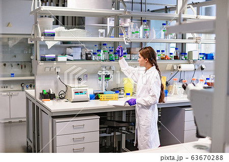 Woman scientist with test tube in hand working in 63670288