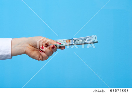 Hands of a young unidentified woman with pack of dollars 63672393