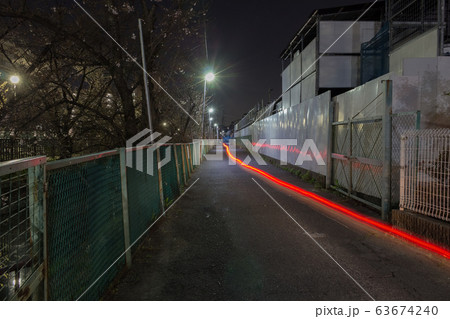 街灯のある深夜の細長い市街地の道路とバイクの光跡 街灯のある深夜の細長い市街地の道路とバイクの光跡 63674240