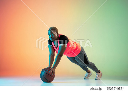 Young african-american plus size female model's training on gradient background 63674624