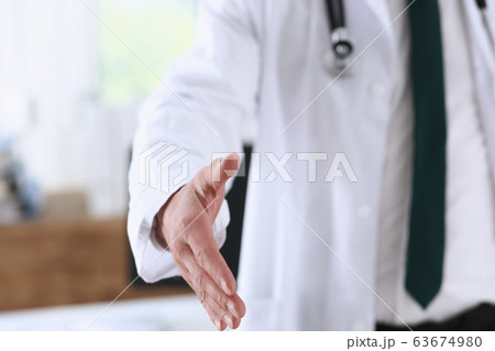 Male medicine doctor offering hand to shake in office 63674980