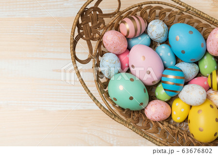 Basket with colorful Easter eggs on wooden 63676802