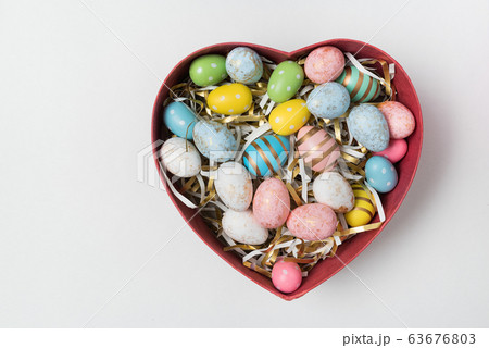 Colorful Easter eggs in heart shaped box on white 63676803