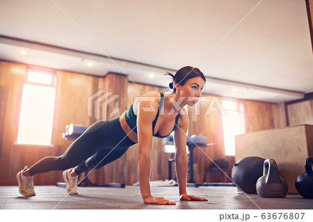 young motivated girl doing plank exercise at gym, full length photo, copy space 63676807
