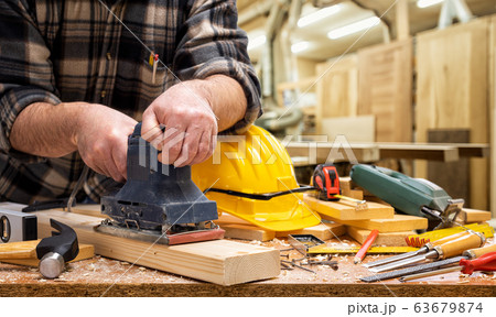 Carpenter at work on wooden boards. Carpentry. 63679874