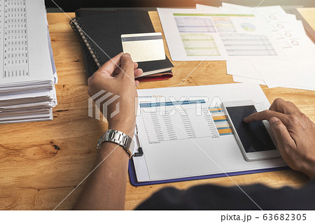 Businessman holding credit card and using smartphone. Businessman holding credit card and using smartphone. 63682305