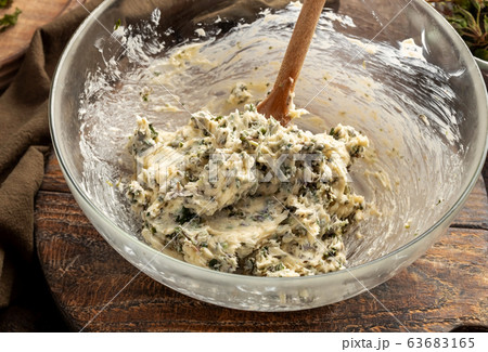 Mixing butter and minced young nettles to prepare herbal butter 63683165