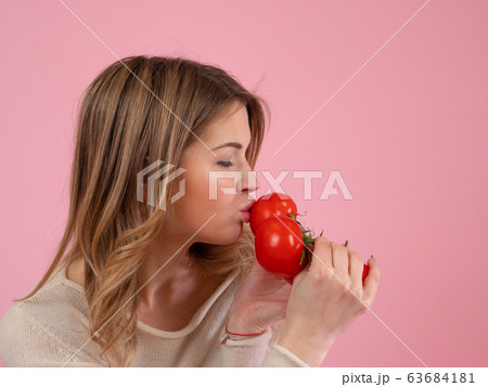 Modern woman kissing ripe tomatoes Modern woman kissing ripe tomatoes 63684181