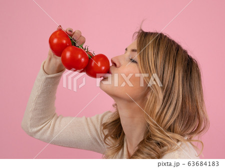 Modern woman kissing ripe tomatoes 63684183