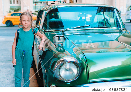 Tourist girl in popular area in Havana, Cuba. Young kid traveler smiling Tourist girl in popular area in Havana, Cuba. Young kid traveler smiling 63687324