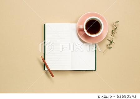Open note book with cup of coffee on beige background. flat lay, top view, copy space Open note book with cup of coffee on beige background. flat lay, top view, copy space 63690543