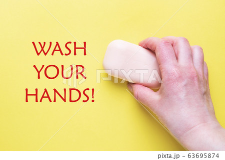 Natural soap in hand on a yellow background. The inscription Wash your hands. copy space. Natural soap in hand on a yellow background. The inscription Wash your hands. copy space. 63695874