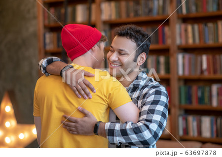 Two young handsome men hugging each other and smiling Two young handsome men hugging each other and smiling 63697878