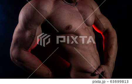 Muscular man showing muscles isolated on the black background