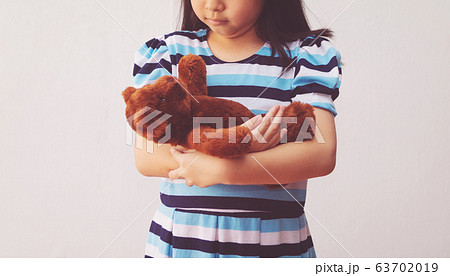asia girl hugging a teddy bear 63702019