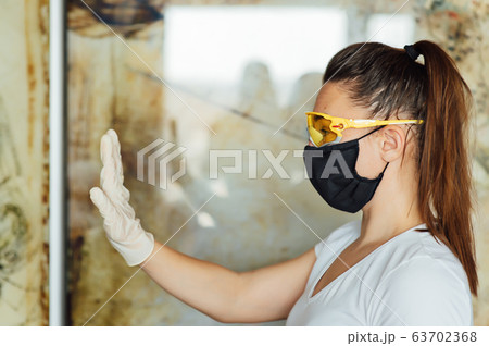 Cute girl shows how to wear a protective mask and glasses 63702368