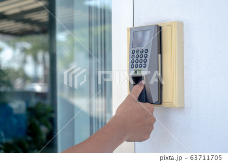 The workers are scanning his fingers to open the door or to stamp time to work. The workers are scanning his fingers to open the door or to stamp time to work. 63711705