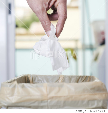 man throwing a used wet wipe to the trash bin 63714771