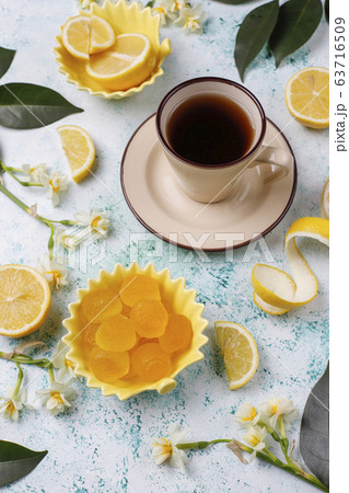 Lemon jelly candies with fresh lemons on light background,top view 63716509