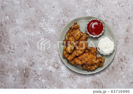 Chicken strips with ketchup and mayonnaise. top view on brown light background. 63716990