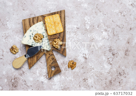 blue cheese on wooden cutting board with honey and walnuts 63717032
