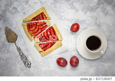 Fresh plum galette pie with raw plums on dark background Fresh plum galette pie with raw plums on dark background 63718007