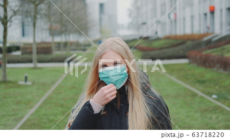 Woman feeling saved by putting on face medical mask Woman feeling saved by putting on face medical mask 63718220
