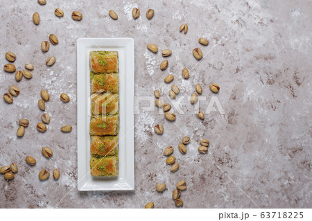 Traditional Turkish Pastry Dessert Baklava with pistachio nuts on concrete background. Traditional Turkish Pastry Dessert Baklava with pistachio nuts on concrete background. 63718225