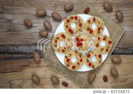 Healthy sandwich. Green apple rounds with peanut butter and red currant and pecan nuts on rustic background,top view Healthy sandwich. Green apple rounds with peanut butter and red currant and pecan nuts on rustic background,top view 63718872