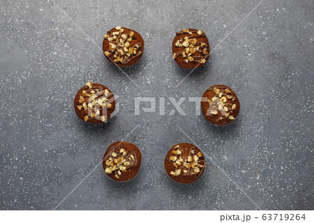 Chocolate-walnut muffins with coffee cup with walnuts on dark background ,Selective Focus. Chocolate-walnut muffins with coffee cup with walnuts on dark background ,Selective Focus. 63719264
