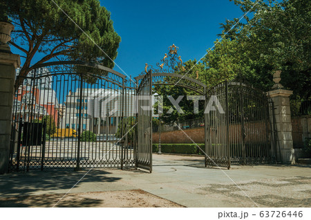 Gateway and wrought iron fence on garden in Madrid 63726446