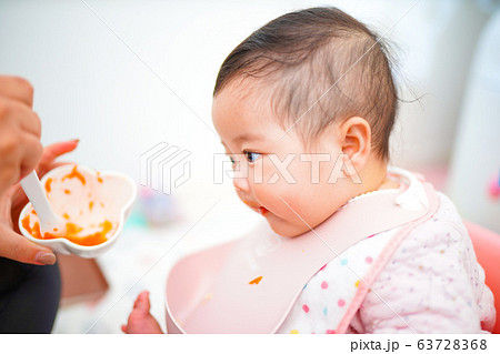 初めての離乳食に興味津々の赤ちゃんの写真素材