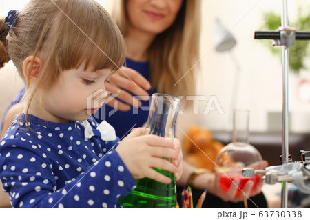 Woman and little girl play with colourful liquids 63730338