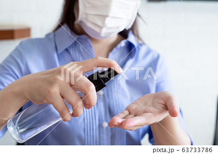 wipes hands with alcohol spray 63733786