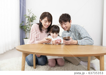 スマートフォンを持つ両親とキッズケータイを持つ5才の女の子 家族イメージ スマートフォンを持つ両親とキッズケータイを持つ5才の女の子 家族イメージ 63735353