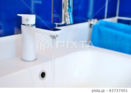 Sink faucet with flowing water closeup Sink faucet with flowing water closeup 63737401