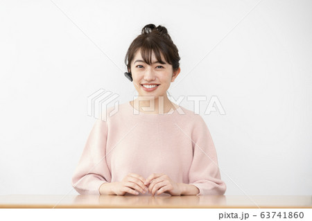 ワイヤレスイヤホンをして話す若い女性 63741860