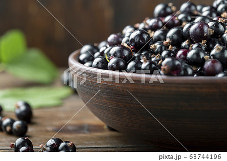 Black currant in a clay bowl top view. 63744196