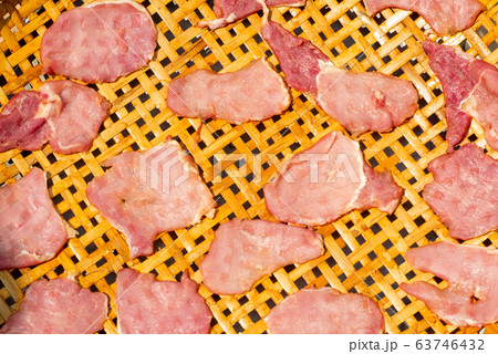 Top view picture of closeup many pieces of pork in the bamboo basket dry by the light of sun Top view picture of closeup many pieces of pork in the bamboo basket dry by the light of sun 63746432