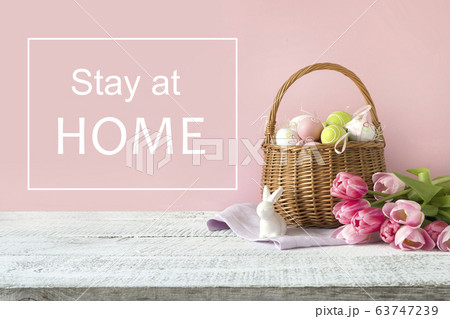 Wicker basket with easter eggs and pink tulips. 63747239