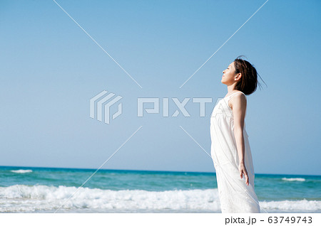 砂浜で光を浴びる女性 63749743