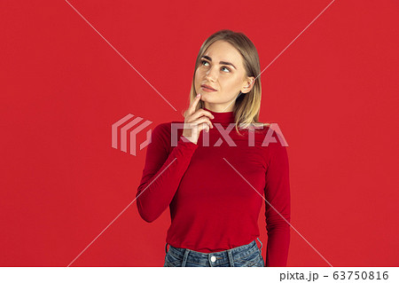 Monochrome portrait of young caucasian blonde woman on red background Monochrome portrait of young caucasian blonde woman on red background 63750816