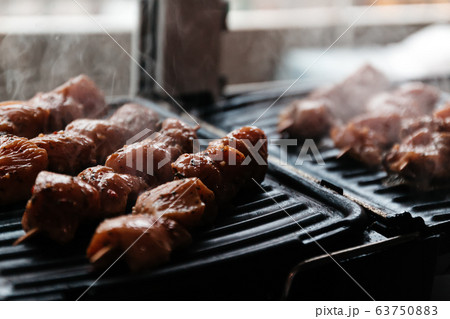 Skewers on skewers from raw meat of pork and beef, chicken cooked on a home electric grill. Top view 63750883