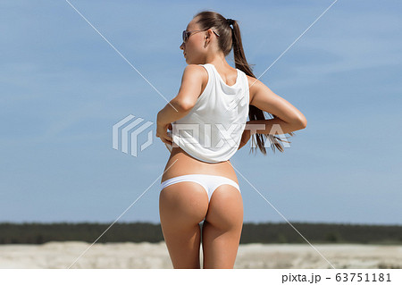Crop woman with firm buttocks on beach 63751181