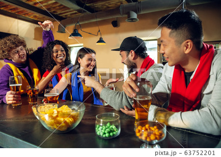 Sport fans cheering at bar, pub and drinking beer while championship, competition is going Sport fans cheering at bar, pub and drinking beer while championship, competition is going 63752201